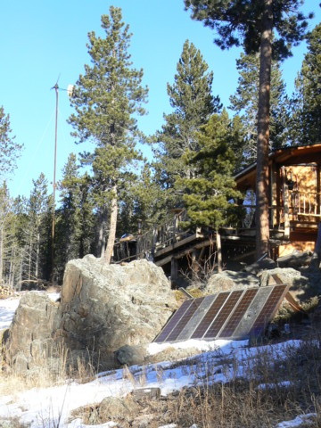 Photo of Rich's cabin with solar panels and windmill